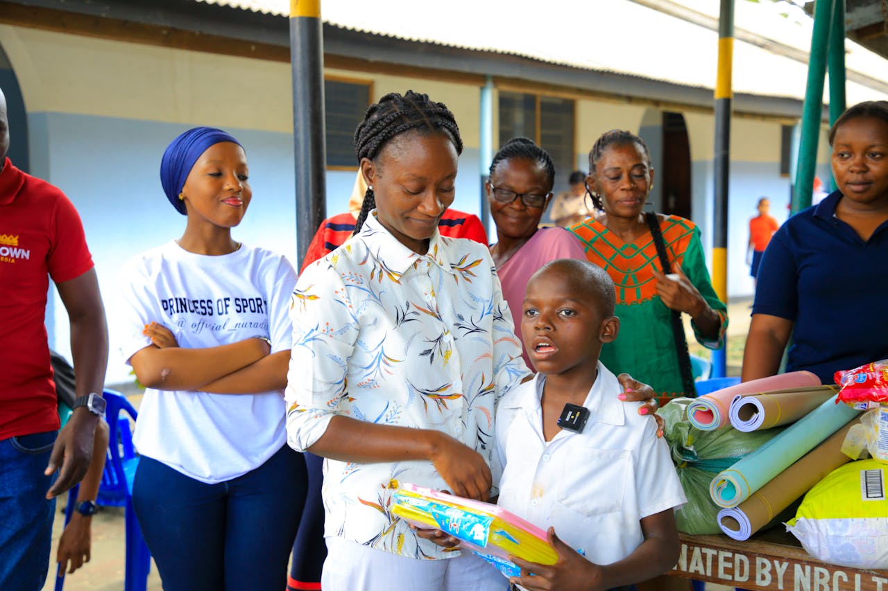 A diverse group of adults and children enjoying a community education event indoors.